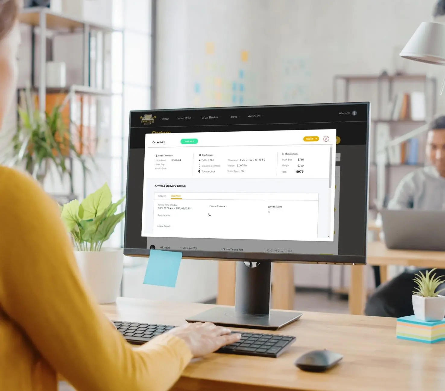 Logistics broker sitting at desktop using the WizeBroker software to match oversized cargoes with local carriers.